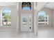 Inviting foyer with elegant front door, arched windows, and tile flooring at 9885 Montclair Circle Cir, Apopka, FL 32703