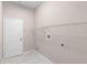 Bright laundry room with sleek tile floors, shelving, and white door at 9885 Montclair Circle Cir, Apopka, FL 32703