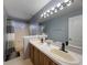 Bathroom featuring double sinks, tile flooring, walk-in shower, and a large mirror at 1010 Sugarberry Trl, Oviedo, FL 32765