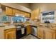 Galley kitchen featuring stainless steel appliances, granite countertops, and wood cabinets at 1010 Sugarberry Trl, Oviedo, FL 32765