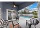 Covered patio featuring stylish furniture overlooking a screened-in pool area at 1010 Sugarberry Trl, Oviedo, FL 32765