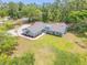 Aerial view of the landscaped front yard, and single-story home surrounded by lush mature trees at 106 Pine Tree Dr, Ormond Beach, FL 32174