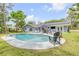 Backyard pool with ample seating, solar panels on roof, and beautifully landscaped surroundings for relaxation at 106 Pine Tree Dr, Ormond Beach, FL 32174