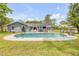 Inviting backyard with a sparkling pool, solar panels, and comfortable seating for outdoor enjoyment and relaxation at 106 Pine Tree Dr, Ormond Beach, FL 32174