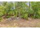 Natural backyard area with mature trees and rocky accent wall at 106 Pine Tree Dr, Ormond Beach, FL 32174