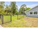 Spacious backyard with a well-maintained lawn, pool and a black chain link fence at 106 Pine Tree Dr, Ormond Beach, FL 32174