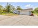 Spacious driveway leading to a home with a two-car garage and a neatly landscaped exterior at 106 Pine Tree Dr, Ormond Beach, FL 32174
