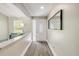 Bright entryway features new wood flooring and a modern mirror; adjacent to the living room at 106 Pine Tree Dr, Ormond Beach, FL 32174