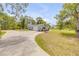 Charming home with a well-maintained exterior, complemented by a curved driveway and mature trees at 106 Pine Tree Dr, Ormond Beach, FL 32174