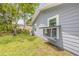 Exterior view of the home featuring a screened-in catio and landscaped backyard with a chain link fence at 106 Pine Tree Dr, Ormond Beach, FL 32174