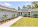 Well-maintained walkway leads to the front door of this charming single-story home with tidy landscaping at 106 Pine Tree Dr, Ormond Beach, FL 32174