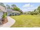 Single-story home with a pristine lawn and neat landscaping, enhanced by a concrete walkway to the entrance at 106 Pine Tree Dr, Ormond Beach, FL 32174