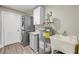 Well-equipped laundry room with newer washer/dryer units, utility sink, cabinet space, and updated flooring at 106 Pine Tree Dr, Ormond Beach, FL 32174