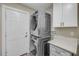 Updated laundry area featuring a modern stacked washer/dryer set and convenient counter space at 106 Pine Tree Dr, Ormond Beach, FL 32174