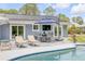 Outdoor patio with lounge chairs, dining table, and a pool, perfect for relaxing and entertaining by the pool at 106 Pine Tree Dr, Ormond Beach, FL 32174