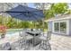 Outdoor patio with dining table under a blue umbrella next to the pool at 106 Pine Tree Dr, Ormond Beach, FL 32174