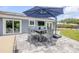 Patio featuring a dining table set under a blue umbrella, perfect for outdoor entertaining at 106 Pine Tree Dr, Ormond Beach, FL 32174