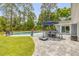 Enjoy the backyard pool with a patio table and chairs for outdoor dining and a serene, private retreat at 106 Pine Tree Dr, Ormond Beach, FL 32174