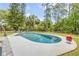 Inviting pool area surrounded by lush greenery and a well-maintained fence at 106 Pine Tree Dr, Ormond Beach, FL 32174