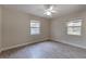 Bedroom features laminate flooring, ceiling fan, and natural light from two windows at 1108 Gibson St, Leesburg, FL 34748
