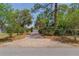 Wide brick driveway leading to an attached two-car garage and a green home with a screened-in porch at 1108 Gibson St, Leesburg, FL 34748