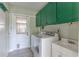 Laundry room with washer, dryer, sink, and green storage cabinets at 1108 Gibson St, Leesburg, FL 34748