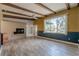 Bright living room with beamed ceilings, fireplace, and large picture window at 1108 Gibson St, Leesburg, FL 34748