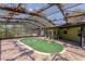 Screened-in pool area with a green pool and brick patio, perfect for outdoor relaxation and entertaining at 1108 Gibson St, Leesburg, FL 34748