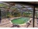 Backyard pool surrounded by a screened enclosure, brick patio, and green water at 1108 Gibson St, Leesburg, FL 34748