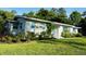 A charming home with a blue front door and shutters surrounded by lush green grass and well-maintained landscaping at 1118 Ne 17Th Ave, Ocala, FL 34470