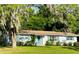 Charming one-story home featuring a well-manicured lawn, blue shutters, and a bright blue front door at 1118 Ne 17Th Ave, Ocala, FL 34470