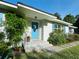 Close-up of the bright blue front door with a unique starfish window accent, complemented by landscaped surroundings at 1118 Ne 17Th Ave, Ocala, FL 34470