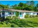 Inviting single story home with white brick, bright blue door and shutters, and beautiful flowerbeds in the landscaped yard at 1118 Ne 17Th Ave, Ocala, FL 34470