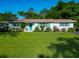 Charming single story home with a well-maintained lawn, bright blue door and shutters, and manicured landscaping at 1118 Ne 17Th Ave, Ocala, FL 34470