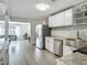 Open kitchen features stainless steel appliances, white cabinets, granite countertops, and wood-look flooring at 1118 Ne 17Th Ave, Ocala, FL 34470