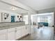 Bright, open concept with wood-look flooring, white cabinets, granite countertops, and a view to the living room at 1118 Ne 17Th Ave, Ocala, FL 34470