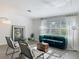 Elegant living room featuring modern decor, a plush green sofa, artwork and abundant natural light at 1118 Ne 17Th Ave, Ocala, FL 34470