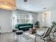 Bright living room featuring a green velvet sofa, stylish seating, and a large window with natural light at 1118 Ne 17Th Ave, Ocala, FL 34470