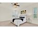 Well-lit bedroom featuring plantation shutters, a ceiling fan, and neutral decor at 112 Overton Gardens Lane, Deland, FL 32724