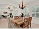 Open-concept dining area adjacent to the living room, featuring a stylish chandelier and plantation shutters at 112 Overton Gardens Lane, Deland, FL 32724