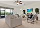 Bright living room featuring neutral decor, comfortable seating, and a ceiling fan at 112 Overton Gardens Lane, Deland, FL 32724