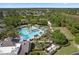 Aerial view of a community pool area with palm trees, cabanas, putting green, and seating at 112 Overton Gardens Lane, Deland, FL 32724
