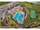 Aerial view of a community amenity center featuring a pool, playground, and tennis courts at 11386 Biography Way, Orlando, FL 32832