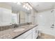 Well-lit bathroom with double sink vanity, granite countertops and shower-tub combo at 11386 Biography Way, Orlando, FL 32832