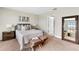 Cozy bedroom featuring neutral tones, an ensuite bath, and a decorative mirror at 11386 Biography Way, Orlando, FL 32832