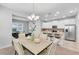 Elegant dining room with modern chandelier open to the kitchen at 11386 Biography Way, Orlando, FL 32832