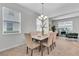 Dining room with stylish chandelier open to living area and natural light at 11386 Biography Way, Orlando, FL 32832