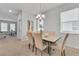 Bright dining room featuring stylish table with seating, modern chandelier, and natural light from the large windows at 11386 Biography Way, Orlando, FL 32832