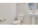 Compact half bathroom featuring a pedestal sink and toilet at 11386 Biography Way, Orlando, FL 32832