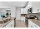 Well-lit kitchen with white cabinets, stainless steel appliances, granite countertops, and an open layout at 11386 Biography Way, Orlando, FL 32832